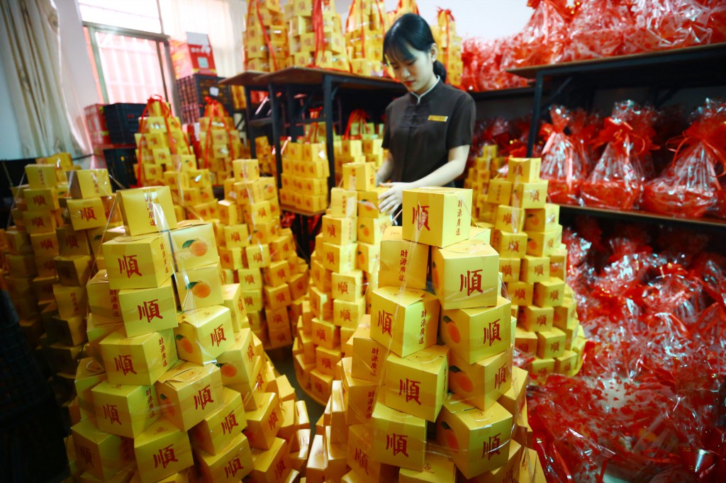 2月8日，工作人員在三亞南山迎財神廟會活動中準備擺放水果1。